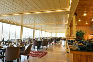 a dining room with tables and chairs and windows at Petra Moon Hotel in Wadi Musa