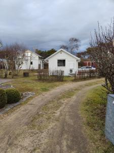 a dirt road in front of a white house at Strandskatan 102 in Halmstad