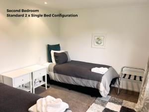 a bedroom with two beds and a desk and a bed at Cambridge Lodge in Cambridge