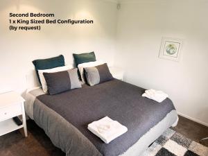 a bedroom with a large bed with two towels on it at Cambridge Lodge in Cambridge +6 photos