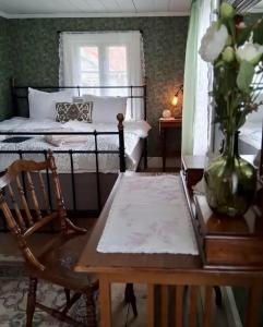 a bedroom with a bed and a table and a chair at Klevs gästgiveri 25 min från Ullared in Mårdaklev +12 photos