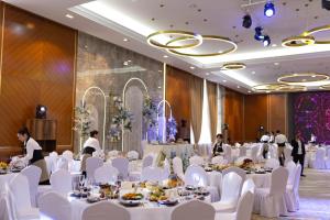 a banquet hall with white tables and white chairs at Hotel Сomplex Irtysh in Pavlodar +53 photos