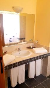 bagno con lavandino, specchio e asciugamani di Royal Horizon Boa Vista a Rabil