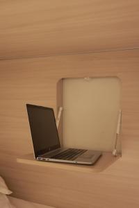 a laptop computer sitting on a wooden shelf at PREMIUM DOO Hostel in Tashkent