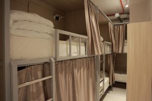 a room with two bunk beds with curtains and towels at PREMIUM DOO Hostel in Tashkent