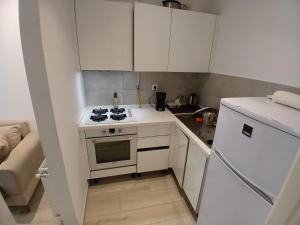 a small kitchen with a stove and a refrigerator at Mon jardin secret in La Marsa