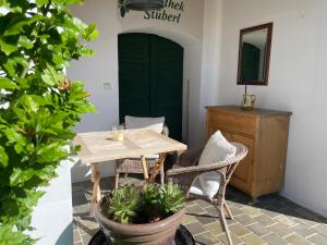 a table and chairs in a room with a green door at Weinlandhaus in Mitterretzbach
