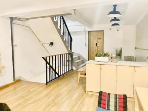 an open kitchen and living room with a staircase at ORA Hostel Bangkok in Bangkok