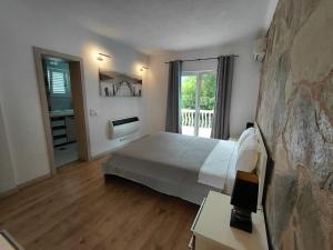 a bedroom with a bed and a stone wall at Muo Suntime apartment in Muo