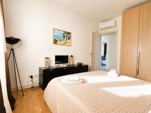 a white bedroom with a bed and a television at Taormina Panoramic Apartment - Taormina Holidays in Taormina +22 photos