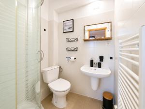 a white bathroom with a toilet and a sink at Pensjonat Natalia Sarbinowo - Blisko Plaży in Sarbinowo