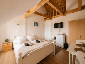 a bedroom with a white bed and a tv at Pensjonat Natalia Sarbinowo - Blisko Plaży in Sarbinowo