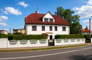 a white house with a red roof behind a white fence at Pensjonat Natalia Sarbinowo - Blisko Plaży in Sarbinowo +16 photos