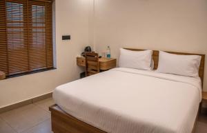 a bedroom with a white bed and a window at Ekana Homes in Trivandrum