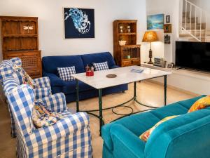 a living room with two blue couches and a table at Casa Denver in El Rompido