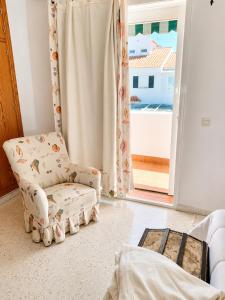 a living room with a chair and a window at Casa Denver in El Rompido +42 photos