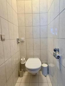 a bathroom with a toilet in a tiled room at Hôtel Albert 1er in Malmedy