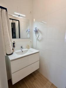 a white bathroom with a sink and a shower at Hôtel Albert 1er in Malmedy