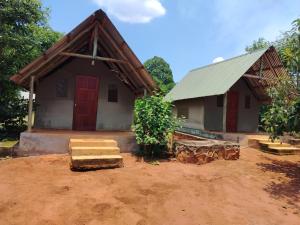 a small house with a red door in the dirt at African Dream Tents in Graskop