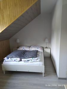 a white bed with pillows on it in a room at Siedlisko - Lipnik, cisza spokój wsród drzew in Nielisz