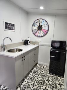 a kitchen with a sink and a clock on the wall at Little Eden in Matamata +3 photos