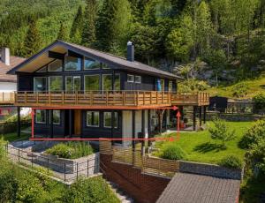 a house with a large deck on a hill at StarapApartment Odda 3 BR in Odda