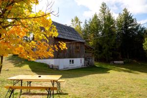 a picnic table in front of a barn at Vukov Konak - Wolf's lodge in Žabljak
