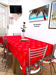a dining room table with a red tablecloth on it at B&B D'Amico87 in Bagheria
