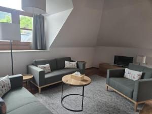 a living room with couches and a table at Ferienwohnung Marienhof in Bad Aussee
