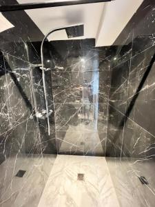 a bathroom with black marble walls and a shower at Cosytel in Bègles