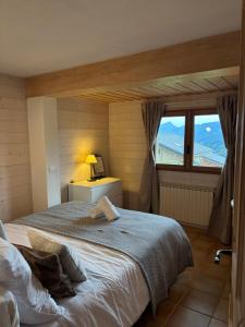 a bedroom with a large bed and a window at Charmant appartement avec jardin et magnifique vue in Saint-Jean-de-Sixt