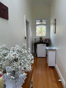 a living room with a table with a vase of flowers at Rose Lodge Bed & Breakfast in Tirau
