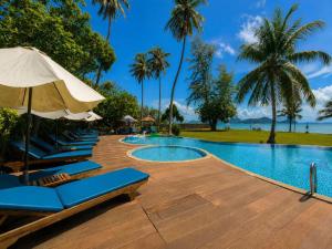 a swimming pool with lounge chairs and an umbrella at Better View Koh Yao Yai in Ko Yao Yai