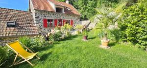 a garden with a yellow chair and a house at un petit coin paisible et frais - piscine à 3 mins in Le Monteil
