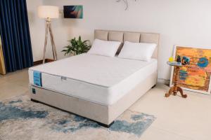 a bed with two pillows on it in a room at Secret Garden Ella Cabana & Stay in Ella