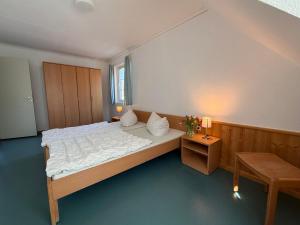 a bedroom with a large bed and a table at martas Gästehäuser Groß Väter See in Templin +96 photos