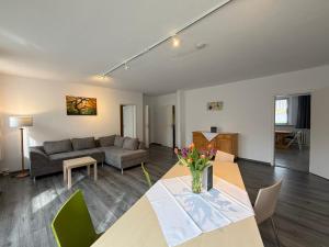 a living room with a table and a couch at martas Gästehäuser Groß Väter See in Templin