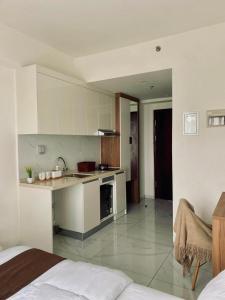 a white kitchen with a sink and a stove at Sky House Hotel Style Bed IKEA 5min in Kampungklapa 2