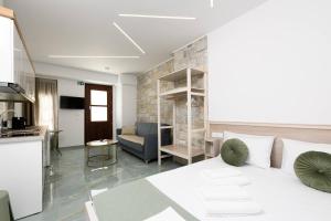 a bedroom with a white bed and a living room at VillAge 1912 Studios in Panagia