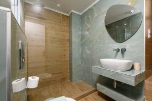 a bathroom with a sink and a mirror at VillAge 1912 Studios in Panagia