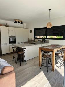 an open kitchen with a wooden table and chairs at Casa di Cortanni in Castellare-di-Casinca +27 photos