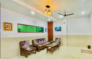 a waiting room with chairs and a green screen on the wall at Sai Sansthan Inn in Lucknow