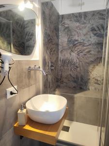 a bathroom with a white sink and a shower at Le stanze del Corso in Monreale