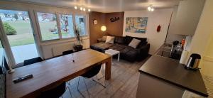 a kitchen and living room with a large wooden table at Haus Samurai in Saas-Grund