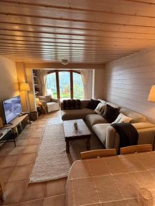 a living room with a couch and a table at Charmant appartement avec jardin et magnifique vue in Saint-Jean-de-Sixt