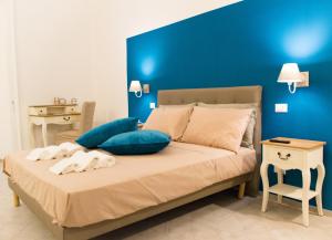ナポリにあるB&B Il Balconcino a Santa Chiaraの青い壁のベッドルーム1室、ベッド1台(タオル付)
