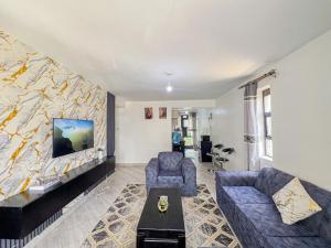 a living room with a couch and a tv at The Escape Muthiga Waiyaki way in Nairobi