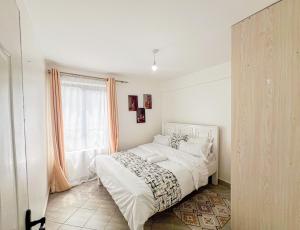 a white bedroom with a bed and a window at The Escape Muthiga Waiyaki way in Nairobi +6 photos