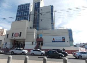 a large building with cars parked in front of it at Hotel cirse cr in Comodoro Rivadavia