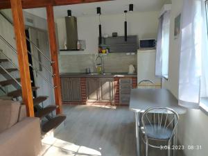 a kitchen with a table and chairs in a room at Siedlisko - Lipnik, cisza spokój wsród drzew in Nielisz